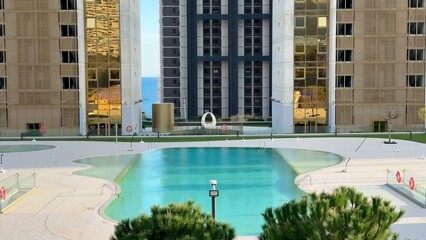 A stunning modern architectural marvel beautifully reflects in the tranquil skyscraper pool