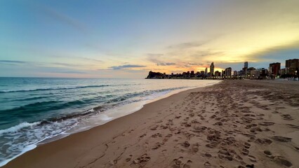 A stunning sunset over the beach with a breathtaking view of the skyline in the distance