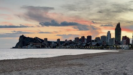 A stunning sunset paints the skyline of a coastal city, creating an aweinspiring view