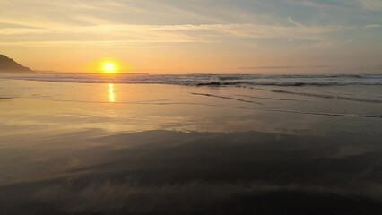 Fototapeta premium Experience the serene beauty of a sunset over peaceful beach waves, a perfect escape