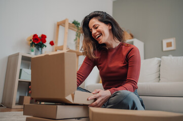 Happy woman opening parcel at home, receiving online order
