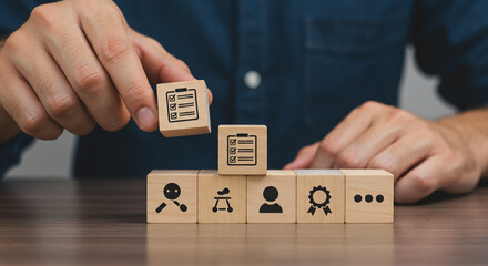 Hand placing wooden block with checklist icon on top of other blocks with various icons shown