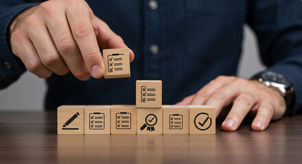 Man stacking wooden blocks with checklist icons on them concept of quality control and assessment