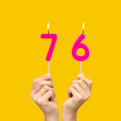 Birthday number 76 - Hands holding fuchsia colored candles