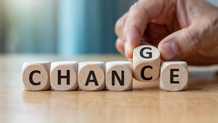A hand manipulates wooden cubes to spell the word 'chance', transforming it to 'change', symbolizing hope, opportunity, and transformation.


