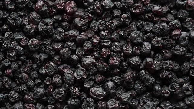 Dried wild blueberries background, rotates, close up, top view, macro. Pile of dry blueberry from dehydrator. Concept of preserving vitamins for winter, healthy eating