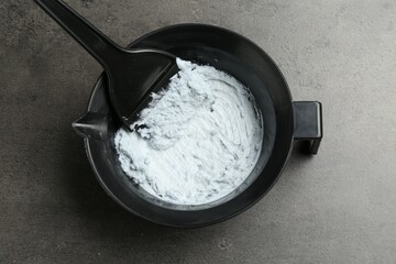 Mixing hair bleaching powder and developer on grey background, top view