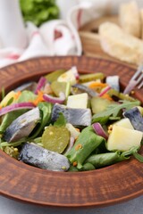Delicious salad with herring and vegetables on table, closeup