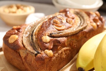 Homemade banana bread with nuts and fruits on table, closeup