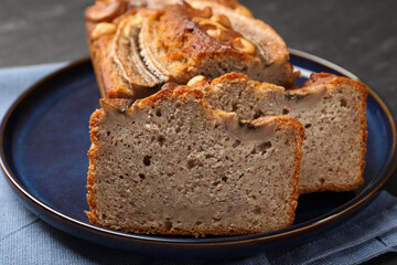 Cut banana bread with nuts on table, closeup