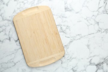 One wooden cutting board on white marble table, top view. Space for text