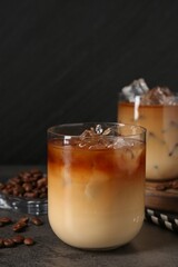 Tasty iced coffee and beans on grey table