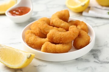 Tasty tempura shrimps and lemon on white marble table, closeup