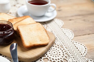 Slices of tasty toasted bread and jam on wooden table, closeup. Space for text