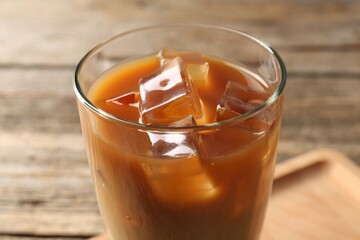 Tasty iced coffee on wooden table, closeup