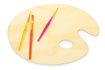 Wooden palette and brushes isolated on white, top view