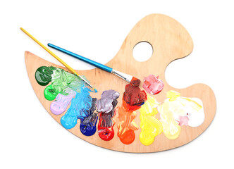 Wooden palette with paints and brushes isolated on white, top view