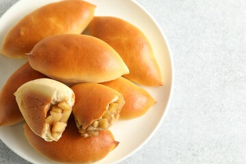Tasty baked patties with apples on light grey table, top view
