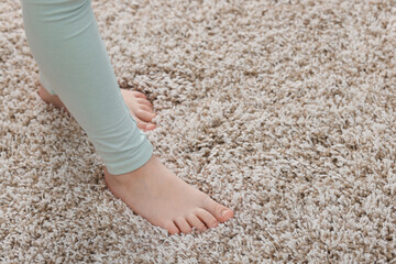 Girl on soft carpet at home, closeup. Space for text