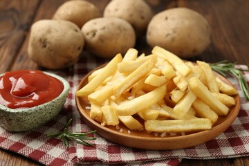 Tasty french fries served with ketchup and rosemary on wooden table, closeup