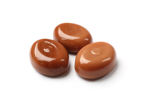 Tasty sweet caramel candies isolated on white