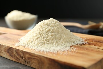 Pile of flour on dark wooden table against black background, closeup