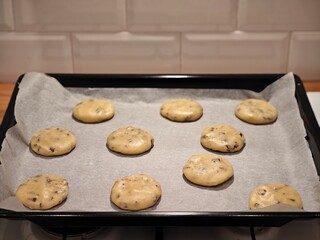 Baking delicious chocolate chip cookies on a baking tray ready for the oven in a cozy kitchen...