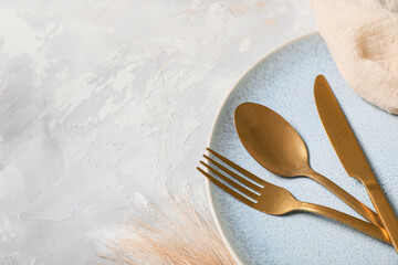 Beautiful table setting with golden cutlery on grey background, closeup