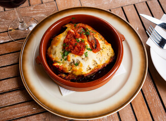 Appetizing baked eggplants and tomatoes with parmesan cheese served on platter