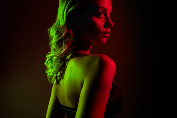 Fototapeta premium Young woman in neon red and green lights showcasing elegance and beauty during a night club party
