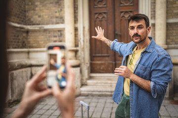 woman record a video of man tourist blogger explain landmark