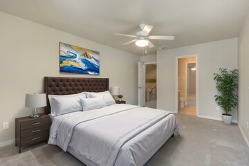 A beautifully designed bedroom with a king size bed and ceiling fan