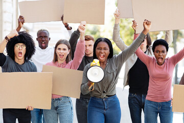 International group young demonstrators striking on the street, holding megaphone and blank...