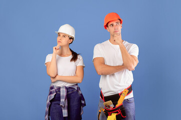 Renovation Planning. Portrait Of Pensive Young Couple In Protective Hard Hats And Casual Clothes...