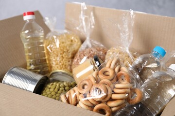 Different food products in box on gray background, closeup