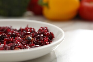 Cockroach crawling on plate with grated red beets on light table, closeup