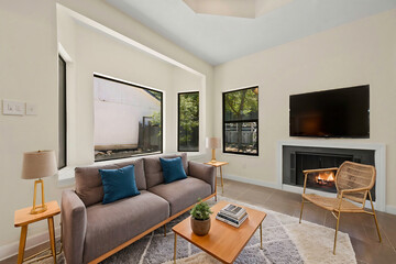 A living room with a couch, table, chair, TV, and fireplace