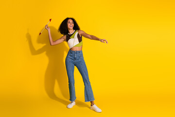 Energetic woman holding a dart showing joy in a cheerful studio shot