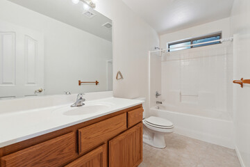 A bathroom featuring a sink, toilet, tub, and a mirror for convenience