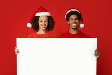 Christmas couple holds white board with copy space and advertise New Year season shopping sale...