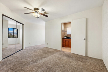 A vacant bedroom featuring a ceiling fan overhead and a window