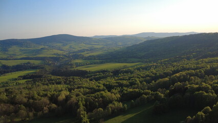 Aerial view of the Czech landscape with mountains and forests at sunset. Scenic spring evening over the Orlické Mountains, Králický Sněžník, and Dolní Morava region