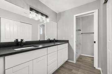 The bathroom features two sinks, a large mirror, and a spacious walkin closet