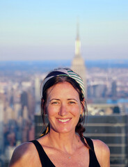 Portrait of beautiful young woman with Manhattan skyscrapers on background, New Your City, USA.