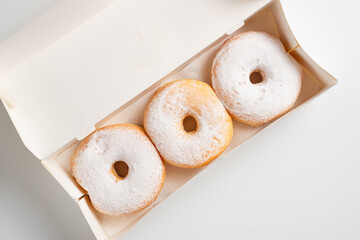 Donuts or Doughnuts. Donut or Doughnut boxes with white sugar sprinkles. Desserts for birthdays, holiday parties. Advertisements for coffee shops, bakeries, cafes, magazines, recipe articles.