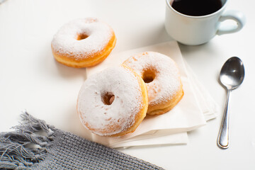 Close-up of fluffy donuts topped with powdered sugar. Sweet pastry texture perfect for bakery ads and dessert-themed visuals.