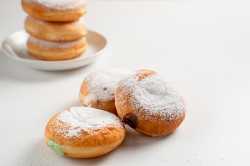 Powdered jelly-filled donuts with creamy fillings on white background – sweet pastry dessert perfect for bakery, breakfast, recipes, articles, snack-theme or any cooking content.