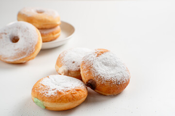 Powdered jelly-filled donuts with creamy fillings on white background – sweet pastry dessert perfect for bakery, breakfast, recipes, articles, snack-theme or any cooking content.