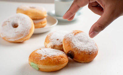 Powdered jelly-filled donuts with creamy fillings on white background – sweet pastry dessert perfect for bakery, breakfast, recipes, articles, snack-theme or any cooking content.