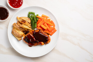 Grilled chicken steak with barbecue sauce, potato wedges, and fresh vegetables. Perfect for healthy lunch, dinner menu content, recipes, articles or any cooking content